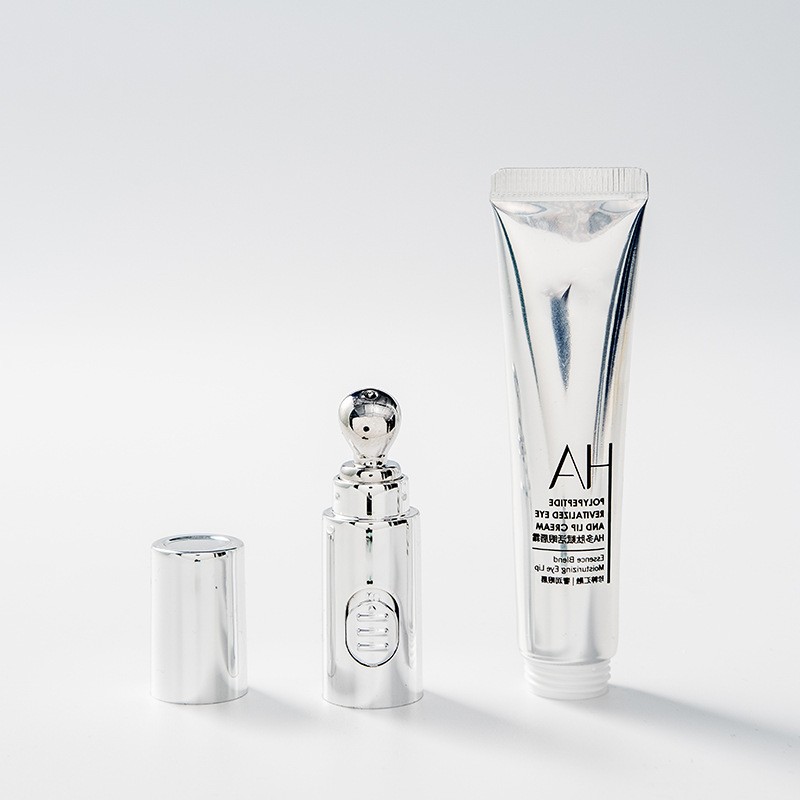 Silver-tone eye cream tube, separate applicator assembly and cap
